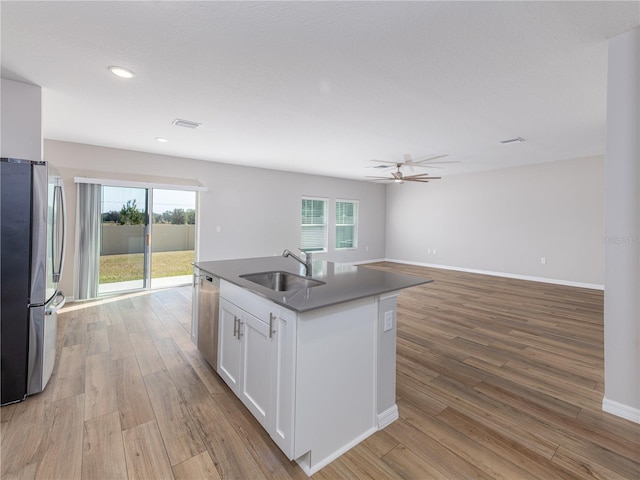 kitchen featuring white cabinets, a center island with sink, sink, appliances with stainless steel finishes, and a healthy amount of sunlight