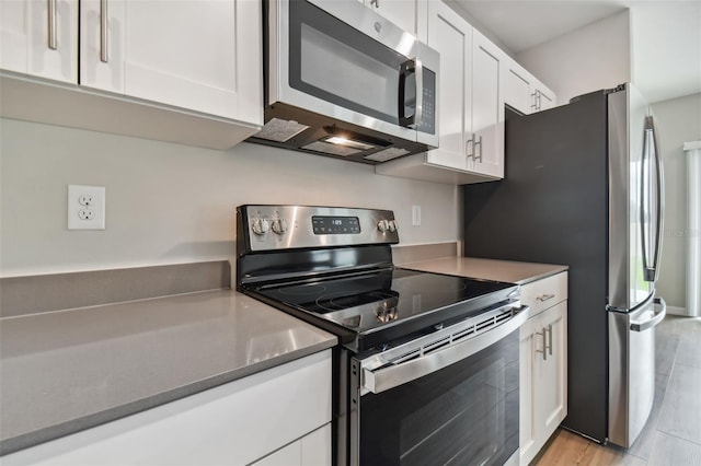 kitchen featuring white cabinets, light hardwood / wood-style floors, and stainless steel appliances