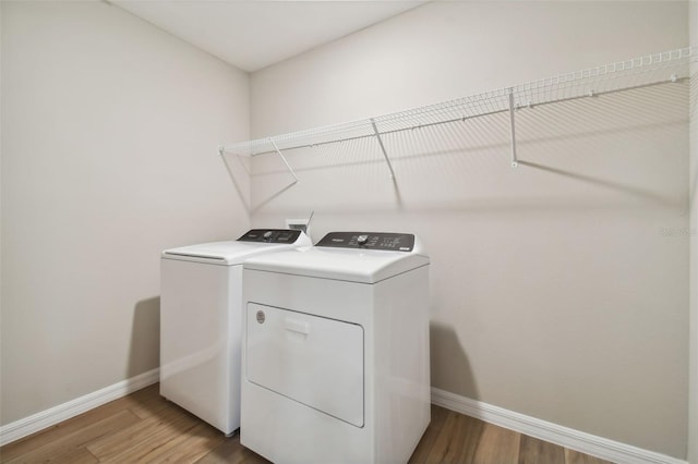 washroom featuring wood-type flooring and washing machine and clothes dryer