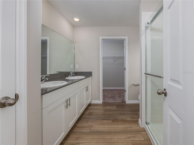 bathroom featuring hardwood / wood-style floors, vanity, and an enclosed shower