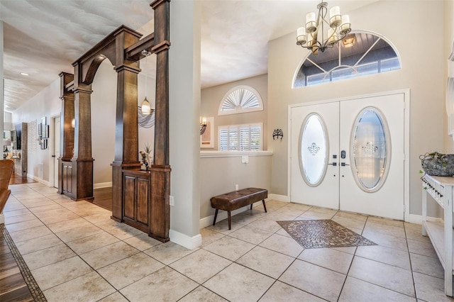 tiled foyer featuring an inviting chandelier