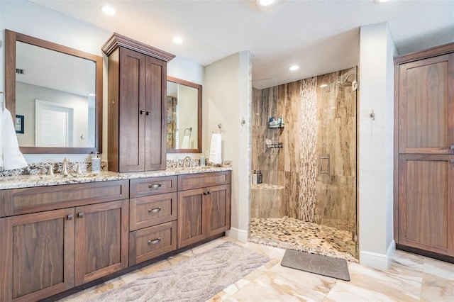 bathroom with a tile shower and vanity