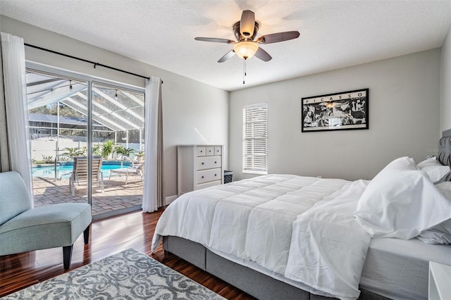 bedroom with a textured ceiling, access to outside, ceiling fan, and dark wood-type flooring