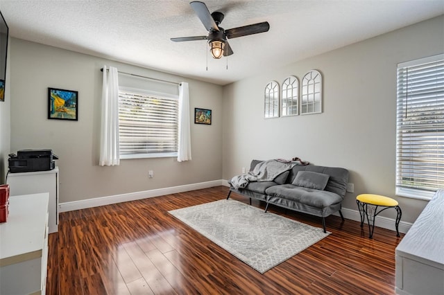 living room with a textured ceiling, ceiling fan, plenty of natural light, and dark hardwood / wood-style floors