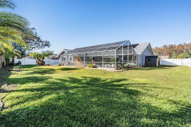 view of yard featuring glass enclosure and a storage shed