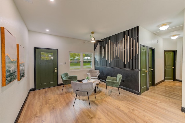 sitting room with ceiling fan and light wood-type flooring