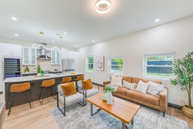 living room featuring sink and light hardwood / wood-style flooring