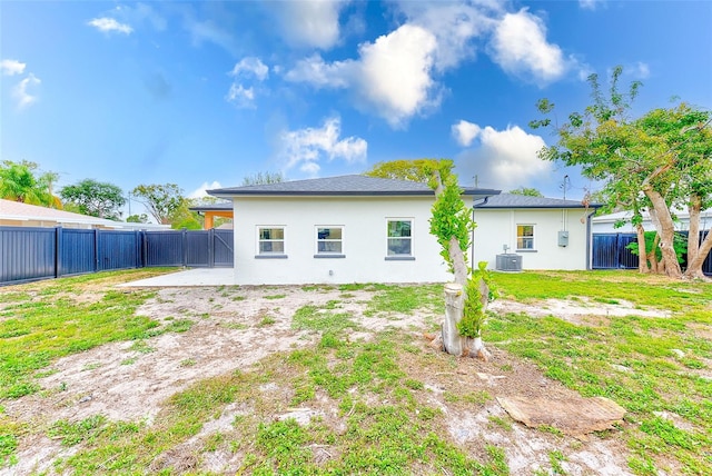 rear view of property featuring a yard and central AC