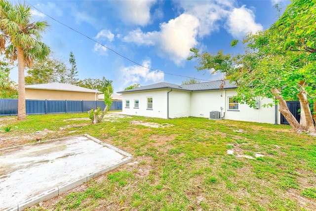 rear view of property featuring a yard, a patio, and cooling unit