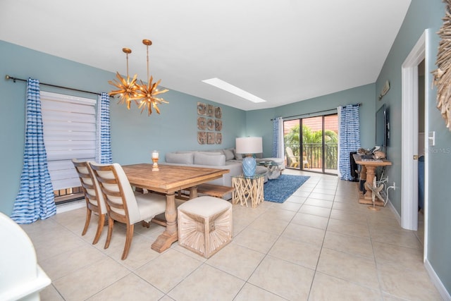 tiled dining area featuring a chandelier and a skylight