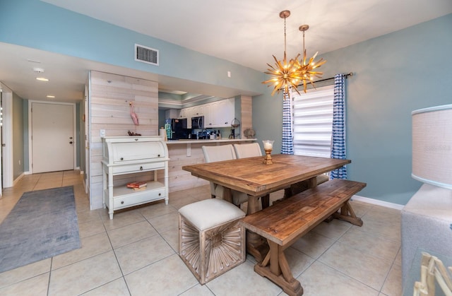 tiled dining space featuring a chandelier