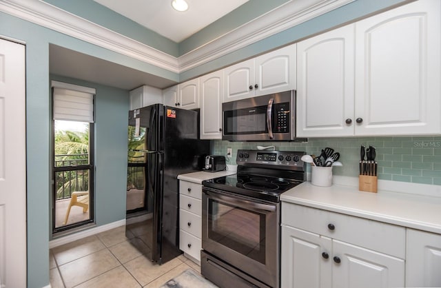 kitchen with light tile patterned flooring, decorative backsplash, white cabinets, and stainless steel appliances