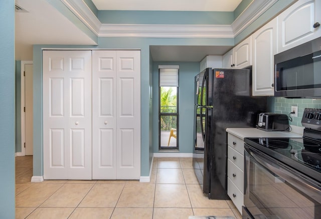 kitchen featuring light tile patterned floors, white cabinetry, appliances with stainless steel finishes, and tasteful backsplash