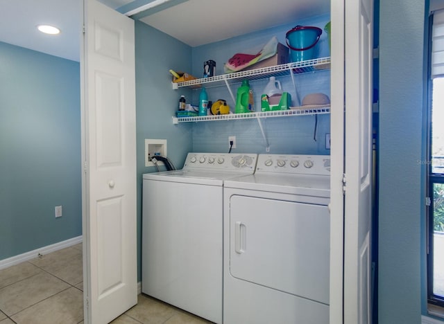 clothes washing area with light tile patterned flooring and washing machine and dryer