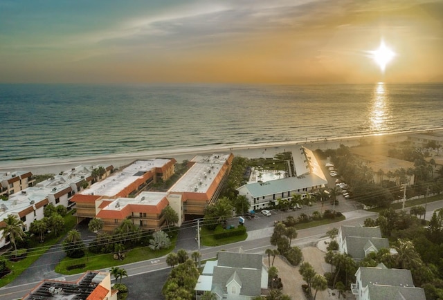 aerial view at dusk with a view of the beach and a water view