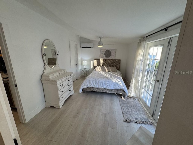 bedroom featuring a wall mounted AC, ceiling fan, and light hardwood / wood-style floors