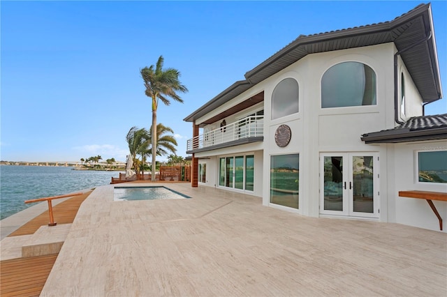 view of swimming pool with a water view and french doors