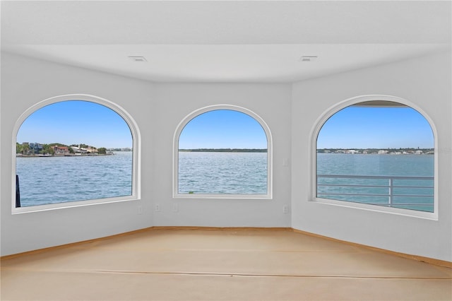 spare room with tile patterned floors and a water view