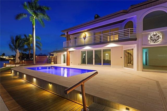 view of pool at twilight