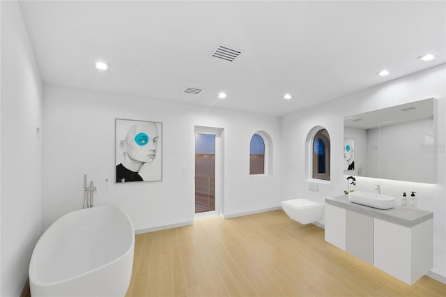 bathroom featuring a washtub, hardwood / wood-style floors, and vanity