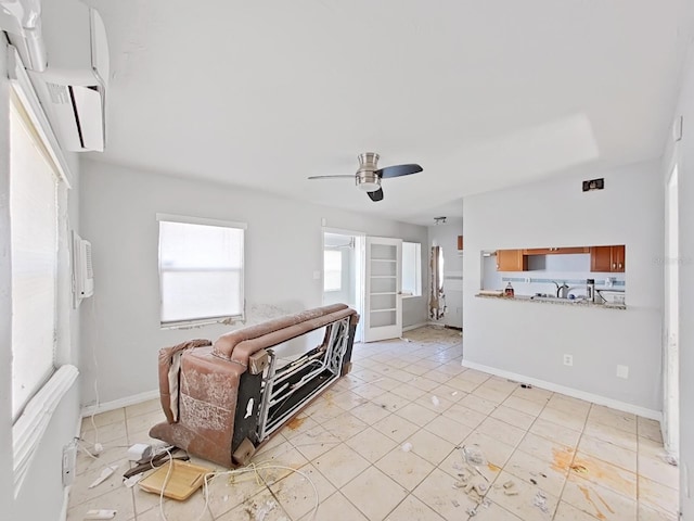 tiled living room featuring ceiling fan and a wall unit AC