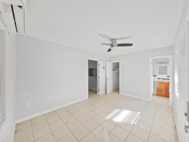 unfurnished bedroom with connected bathroom, ceiling fan, light tile patterned floors, and a spacious closet