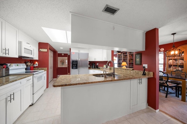 kitchen with kitchen peninsula, sink, white cabinets, and white appliances