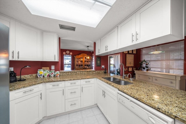 kitchen featuring white cabinets, dishwasher, kitchen peninsula, and sink