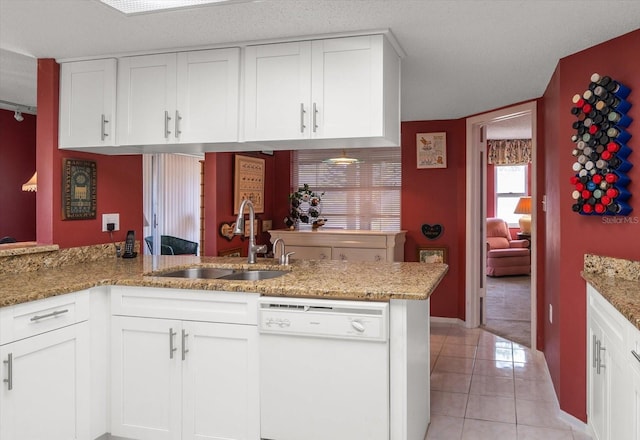 kitchen with white cabinets, dishwasher, kitchen peninsula, and sink