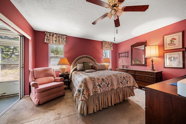 bedroom featuring a textured ceiling, light colored carpet, and ceiling fan