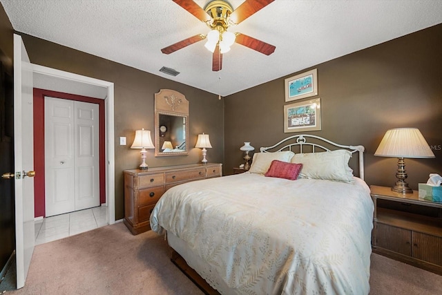 bedroom with light carpet, a textured ceiling, a closet, and ceiling fan