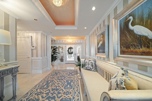 hall with a raised ceiling and crown molding