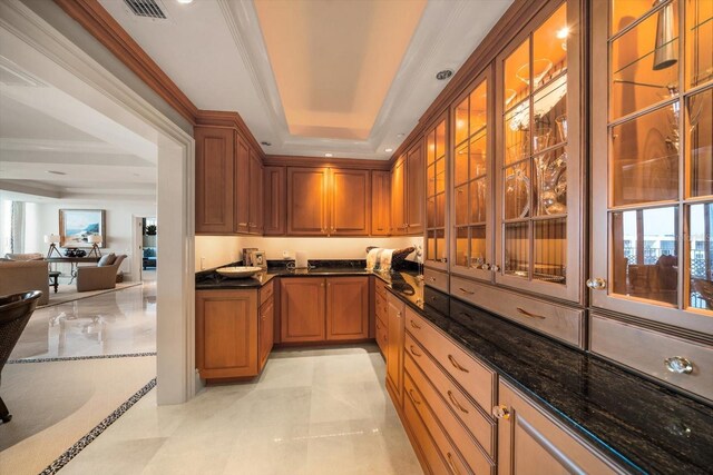 bar with a raised ceiling, dark stone countertops, and crown molding