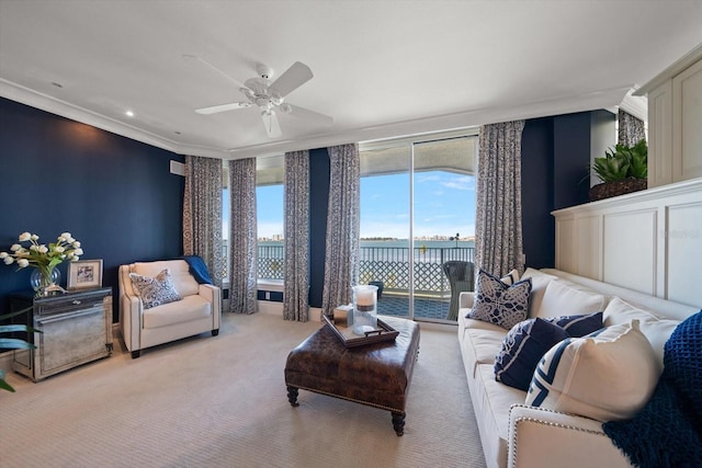 carpeted living room with ceiling fan and ornamental molding