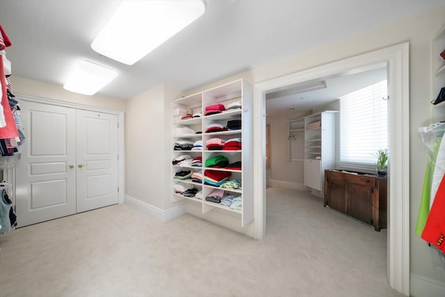 walk in closet featuring light colored carpet