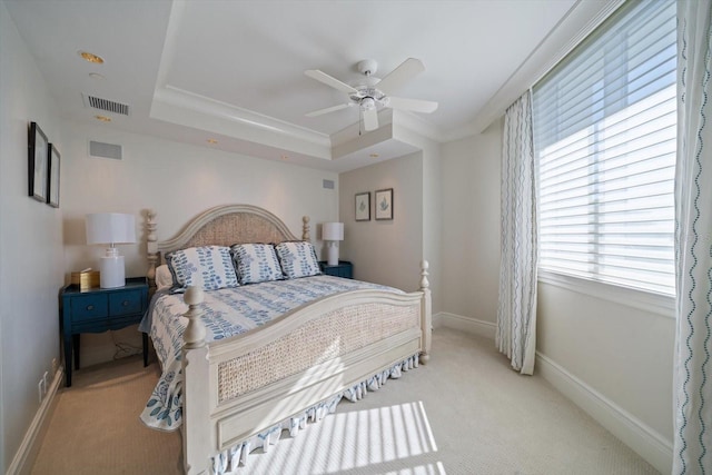 bedroom featuring a raised ceiling, ceiling fan, crown molding, and light colored carpet