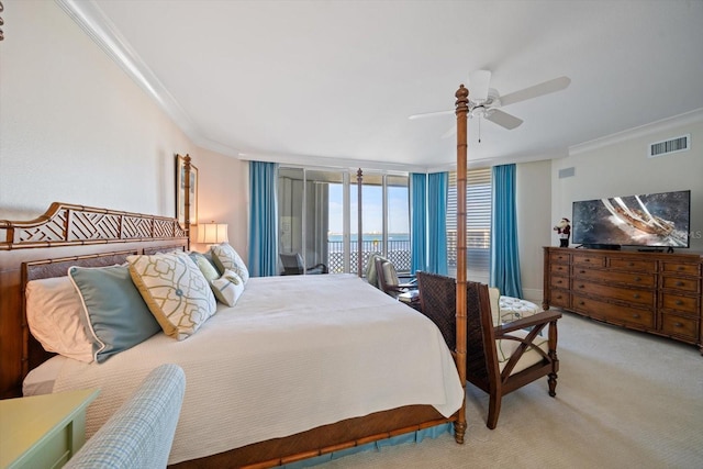 carpeted bedroom with ceiling fan, crown molding, and a wall of windows