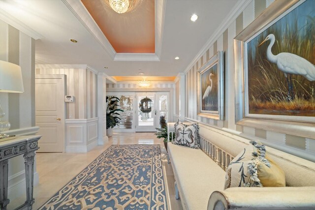 hallway with recessed lighting, ornamental molding, a raised ceiling, and a decorative wall