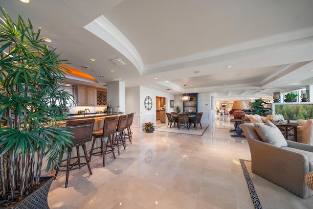 interior space with visible vents, ornamental molding, a raised ceiling, and recessed lighting