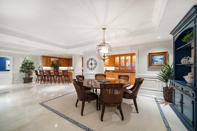 dining area featuring a wainscoted wall, recessed lighting, a raised ceiling, and a decorative wall