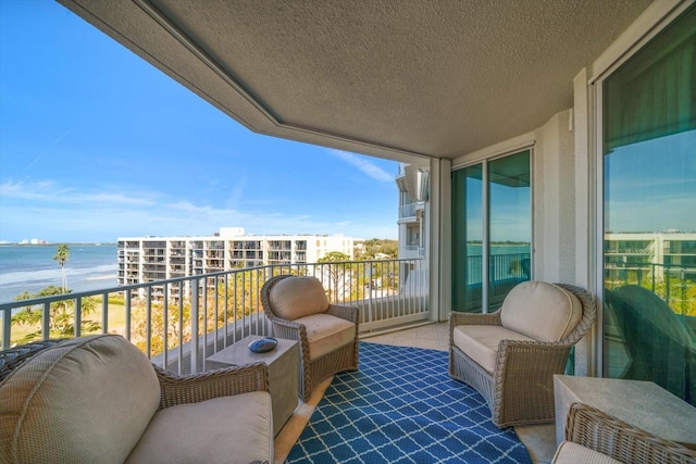 balcony featuring a sunroom and a water view