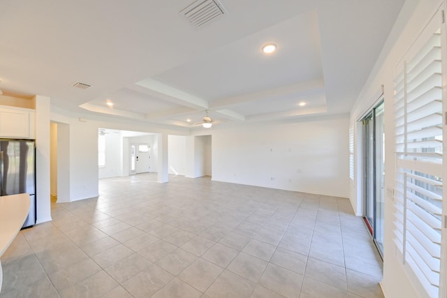 tiled spare room with a tray ceiling and ceiling fan