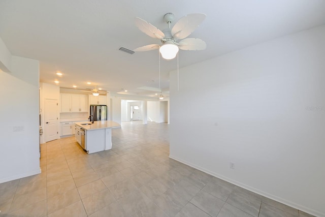 kitchen with white cabinets, ceiling fan, light tile patterned floors, a kitchen island, and stainless steel appliances