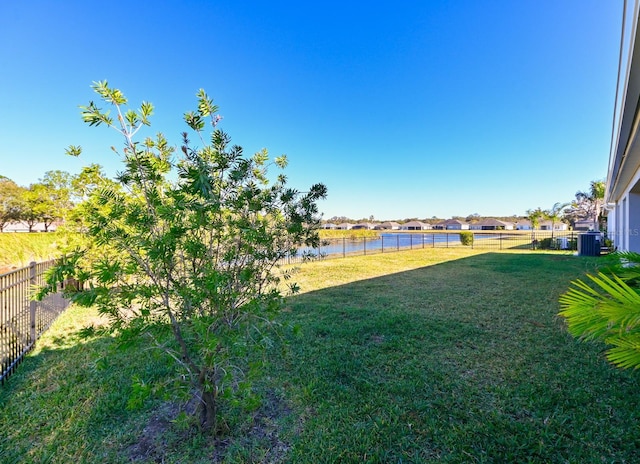 view of yard with a water view and central air condition unit