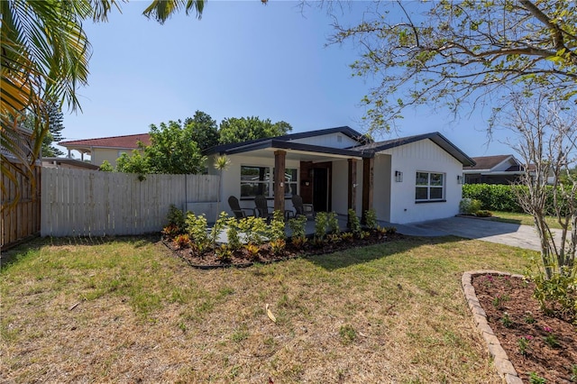 view of front of house with a patio and a front yard