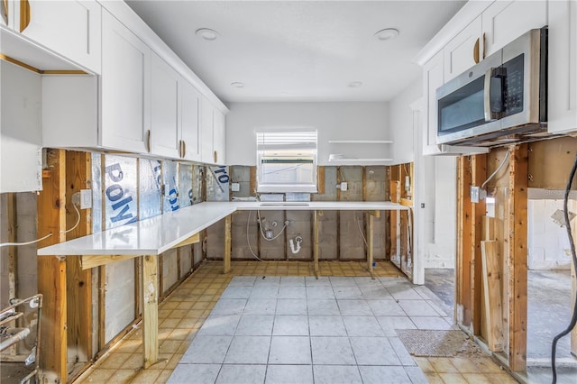 kitchen featuring white cabinets, decorative backsplash, and light tile patterned floors