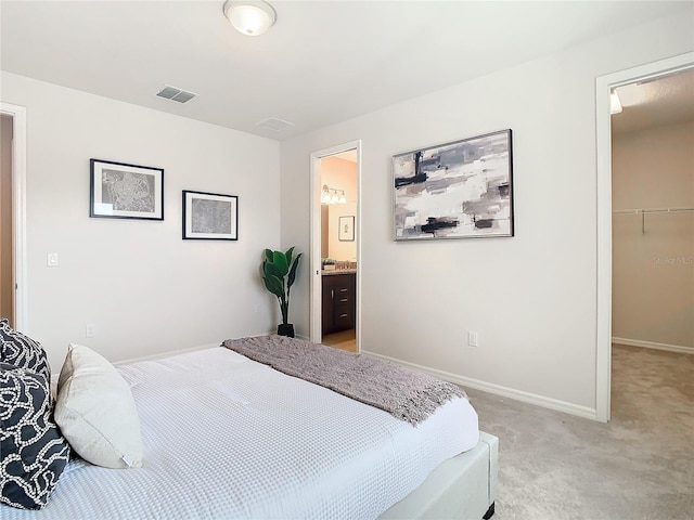 carpeted bedroom with connected bathroom, a spacious closet, and a closet