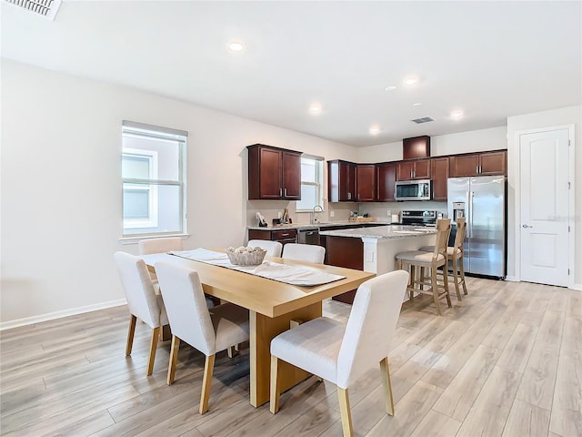 dining area with light wood-type flooring and sink