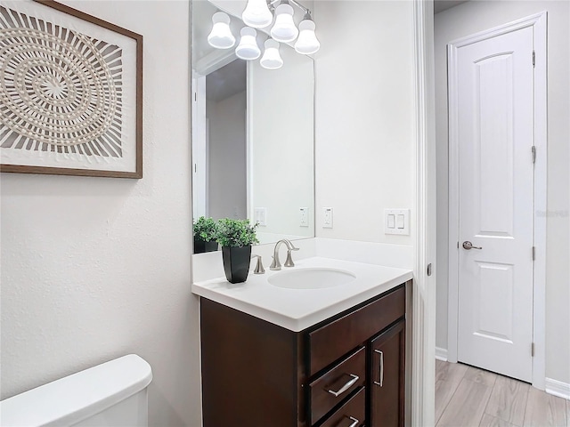 bathroom featuring hardwood / wood-style floors, vanity, and toilet