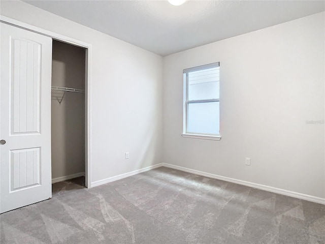 unfurnished bedroom with light carpet and a closet